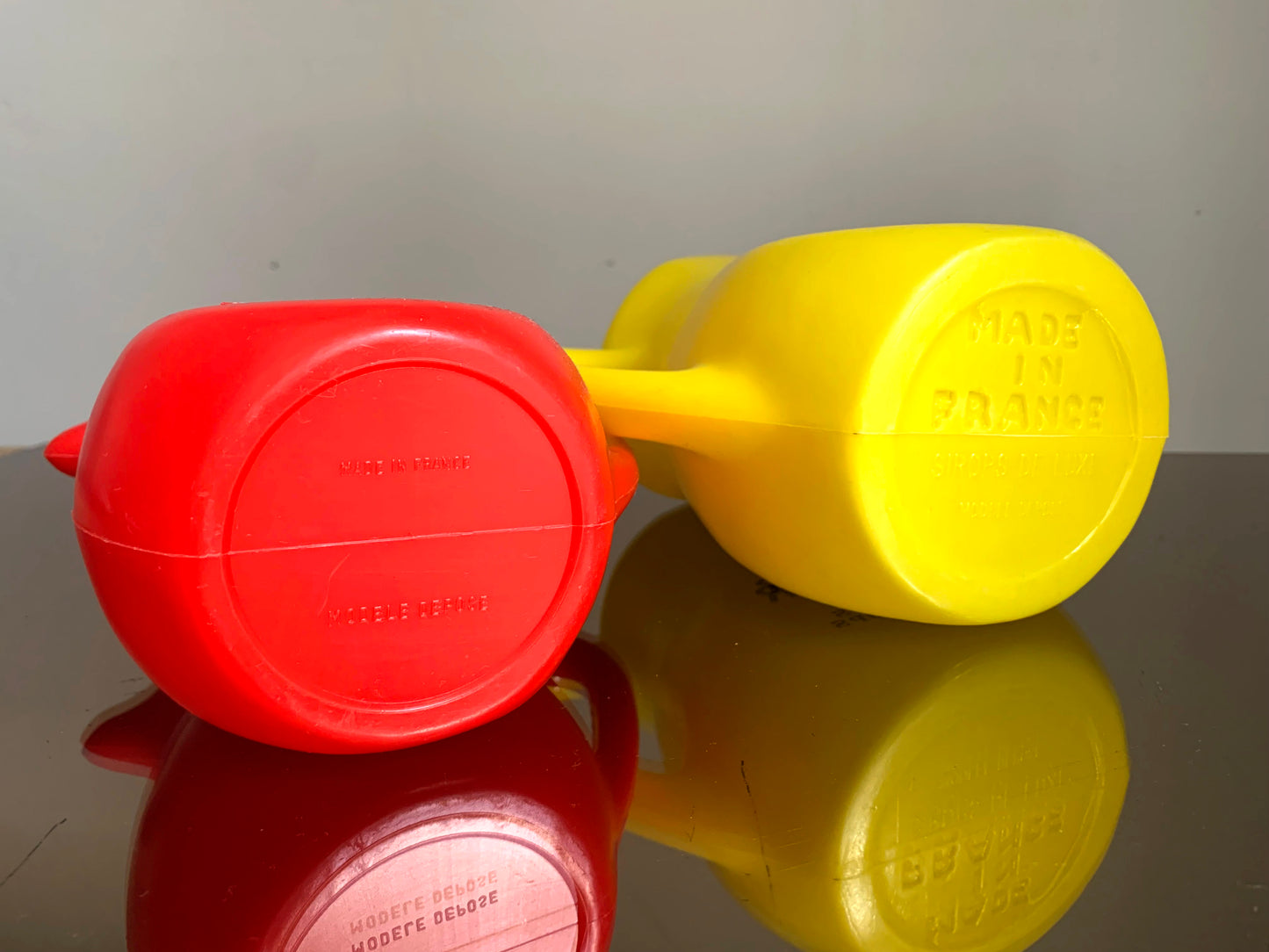 A Pair of Vintage French Berger Anisette & Sirops Red & Yellow Plastic Jugs