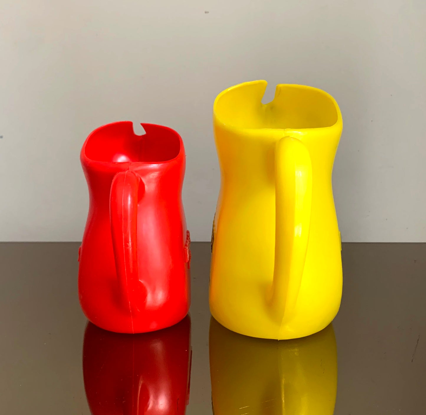 A Pair of Vintage French Berger Anisette & Sirops Red & Yellow Plastic Jugs